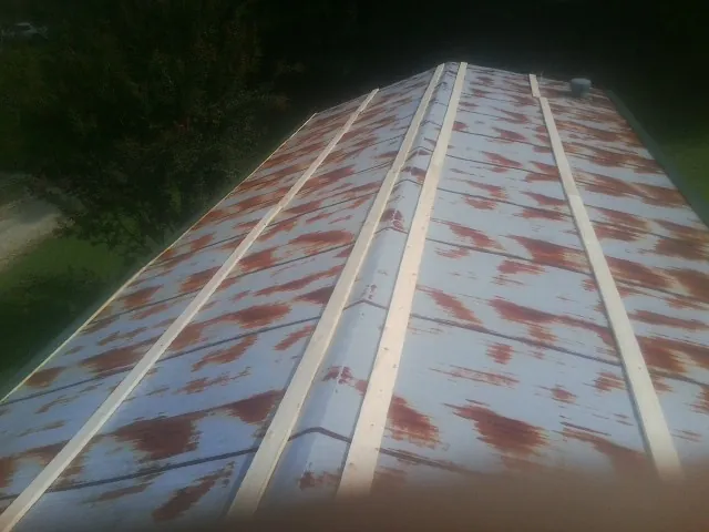 Rusted metal roof panels with new wood purlins before replacement — Storm Damage Roof Repair in Claremore by Roofing Brothers