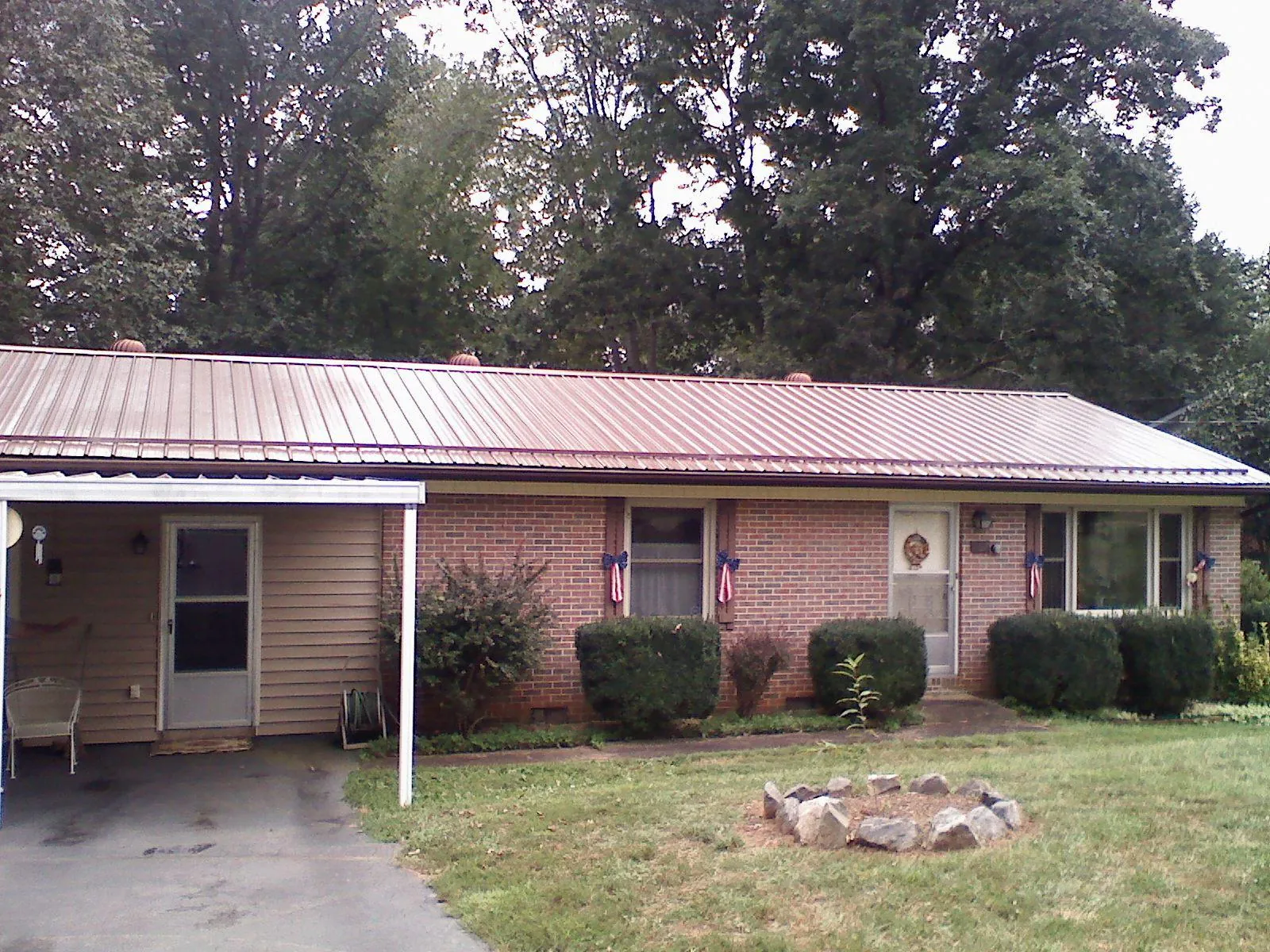 Bronze metal roof and carport on a brick ranch home — Roof Repair work by our crew in Claremore