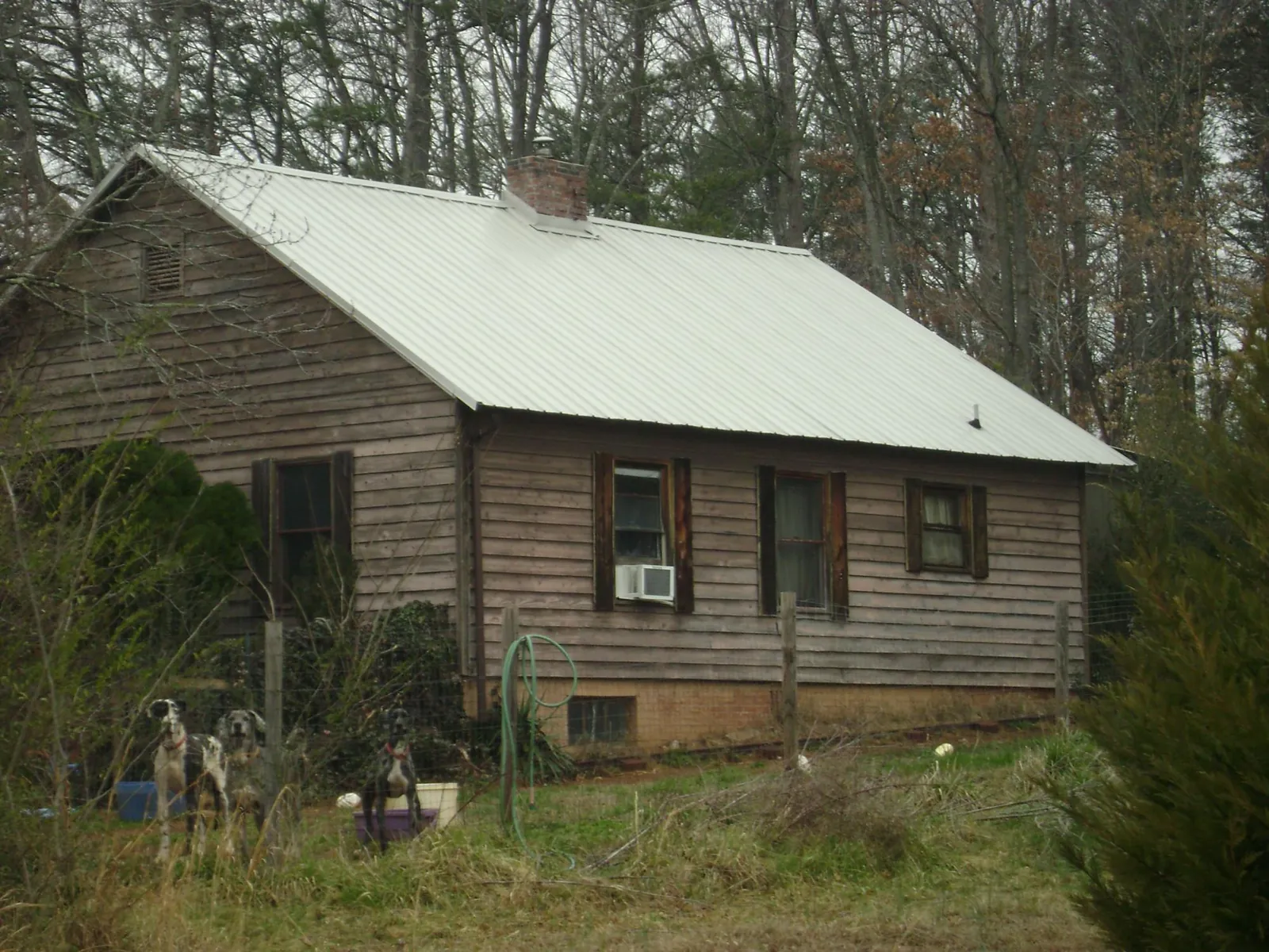 White metal roof on an old wood sided farmhouse, from a Asphalt Shingle Roof Repair job in Claremore